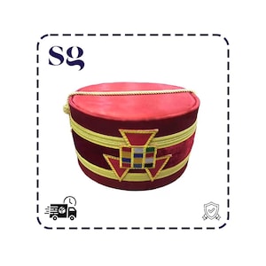 May include: A red and burgundy ceremonial hat with gold trim and a decorative emblem. The hat has a rounded top and a cylindrical base. The emblem features a geometric design with various colors.
