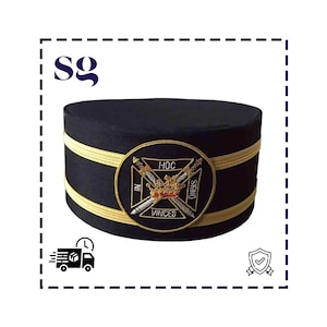 May include: A black cap with gold bands and a circular emblem. The emblem displays a crown, crossed swords, and the Latin phrase "IN HOC SIGNO VINCES". The cap is flat-topped and cylindrical.