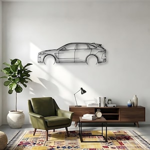 May include: A black metal wall art piece depicting the side profile of a car. The artwork is mounted on a white wall above a mid-century modern living room setup. The room includes a green armchair, a patterned rug, and wooden furniture.