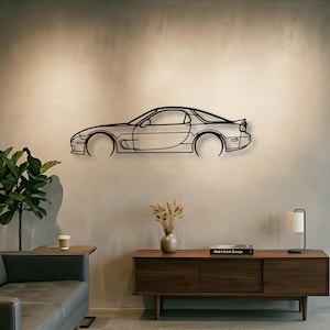 Può includere: Un'opera d'arte da parete in metallo nero raffigurante il profilo laterale di un'auto sportiva. L'opera è montata su una parete di colore chiaro, mostrando il contorno dell'auto con dettagli precisi. Le ruote dell'auto sono rappresentate da cerchi aperti.