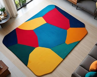 May include: A colorful geometric area rug with a vibrant design. The rug features large, irregular shapes in shades of blue, red, yellow, green, and orange. The rug is rectangular with rounded corners and is placed on a light-colored wooden floor.