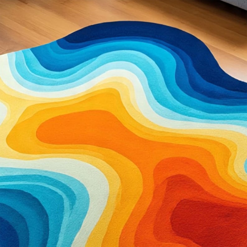 May include: A colorful, abstract rug with a layered design. The rug features a gradient of colors, including shades of blue, orange, yellow, and white. The rug's shape is organic and flowing, adding a modern touch to any space.