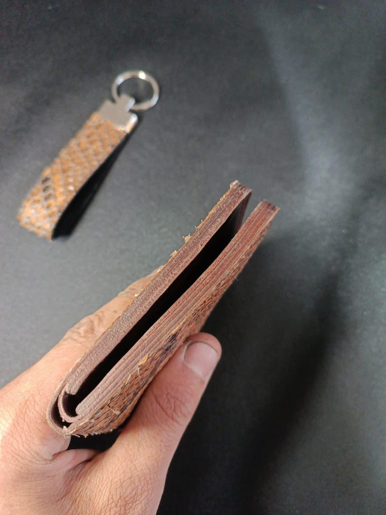 wallet with an exotic embossed finish and matching leather keychain accessory."