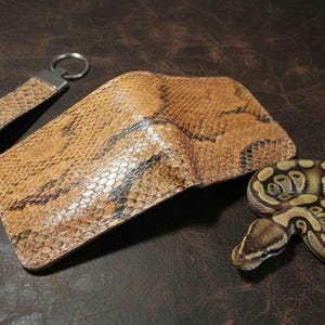 leather wallet showcasing a natural scale-like texture in earthy tones on a dark background."