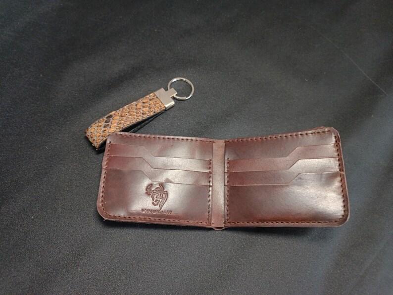 Designer Patterned Bifold: "Elegant designer wallet with a unique scale-effect finish, displayed open to show interior craftsmanship