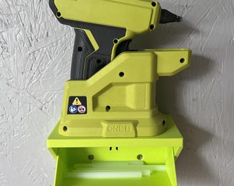 Può includere: Una pistola per colla senza fili verde lime e nera con un vassoio portaoggetti abbinato. La pistola per colla è etichettata "ONE+" e presenta un simbolo di avvertimento. Il vassoio è aperto, rivelando diversi stick di colla.