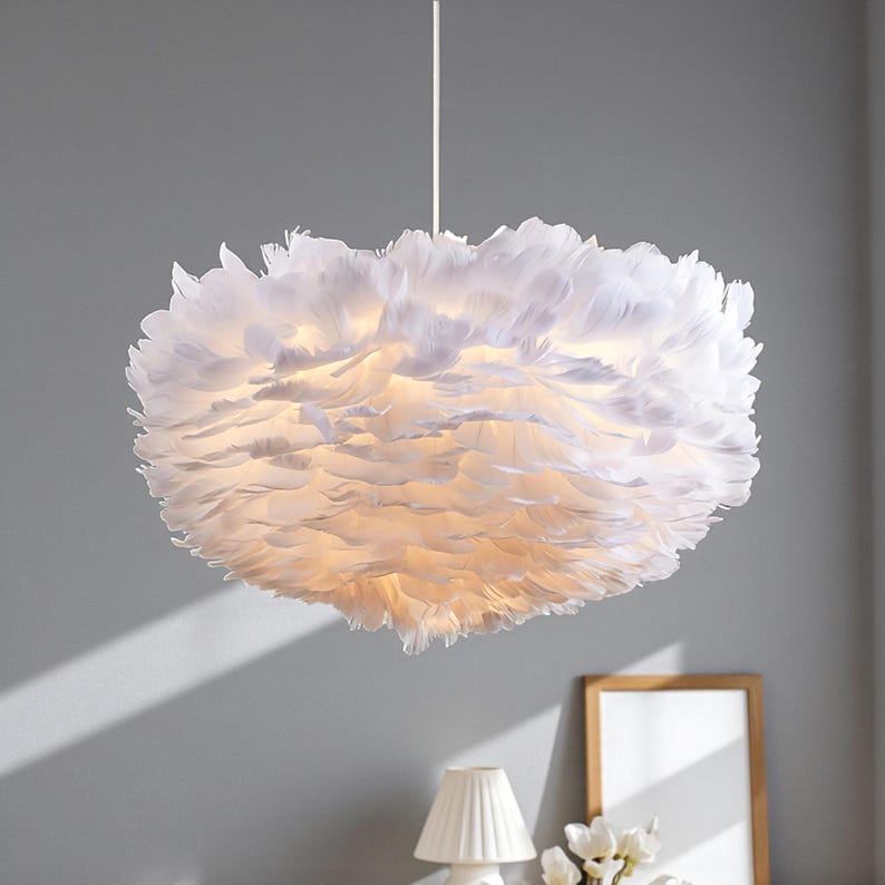 May include: A white, feather pendant light. The light fitting is round, resembling a cloud due to the many white feathers. It hangs from a white cord and provides a soft, ambient glow to the room.
