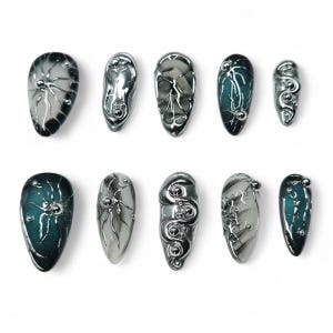 May include: A set of ten press-on nails featuring a variety of designs including metallic silver liquid-like textures, raised spherical accents, and deep teal and black gradients. Each nail has a unique, sculpted, three-dimensional surface finish.