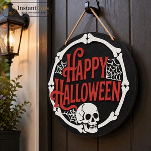 Könnte beinhalten: Ein rundes schwarzes Holzschild, das an einem Juteseil hängt und in der Mitte den roten Schriftzug "HAPPY HALLOWEEN" trägt. Das Schild ist mit einem weißen Rand aus Knochen, zwei weißen Spinnennetz-Illustrationen und einem weißen Totenkopf verziert.