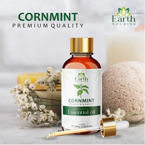 Puede incluir: Un frasco de vidrio marrón de aceite esencial de menta de campo Earth Nourish de calidad premium con tapa dorada y un gotero de vidrio separado. La etiqueta muestra una ilustración de planta verde, el texto Cornmint y 30 ml.