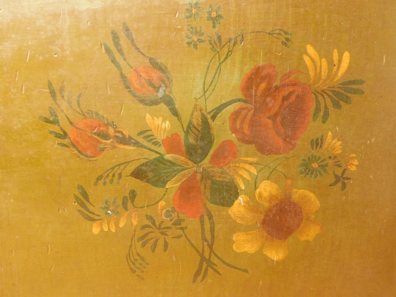 May include: A painted floral design featuring red roses, orange buds, and yellow sunflowers on a gold background. The artwork includes green leaves and stems, creating a vintage, botanical theme.