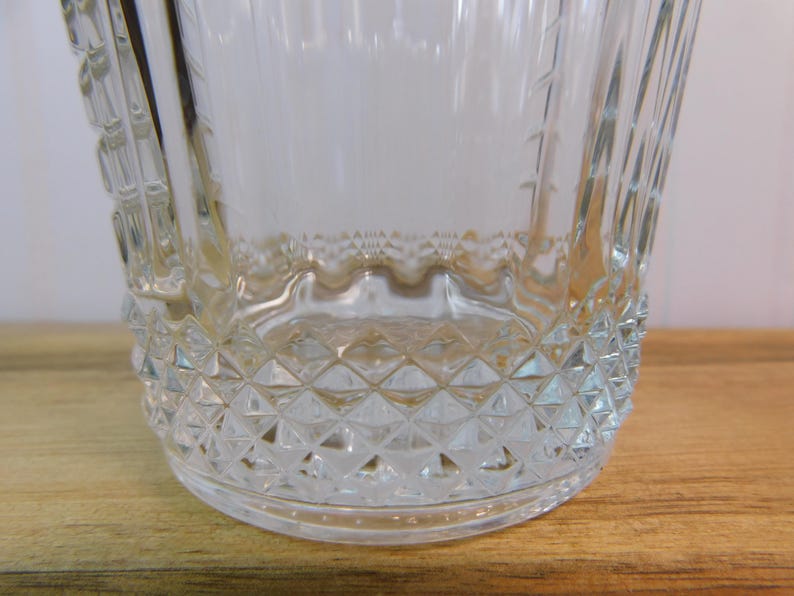 Pode incluir: Balde de gelo de vidro transparente com um padr&atilde;o de diamante na base e uma al&ccedil;a texturizada. O balde tem uma borda ondulada e linhas verticais nas laterais. O vidro &eacute; transparente.