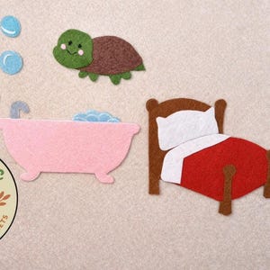 May include: Felt cutouts of a turtle, bathtub, bed, and bubbles. The turtle is green and brown with a smiling face. The bathtub is pink with blue bubbles. The bed has a red blanket and white pillow.