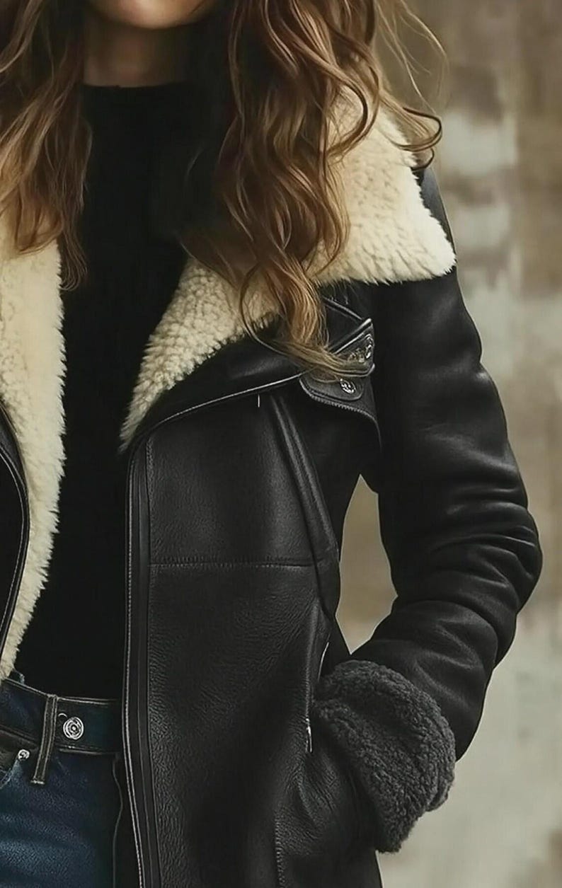Peut inclure: Veste en cuir noir avec col et doublure en peau de mouton cr&egrave;me. La veste pr&eacute;sente une fermeture &eacute;clair asym&eacute;trique classique, un revers crant&eacute; et un aspect chaleureux. Les manches ont un poignet en peau de mouton.