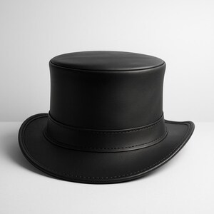 May include: A black top hat with a rounded crown and a wide brim. The hat is made of a smooth, leather-like material and features a band around the base of the crown. The hat is a classic accessory.