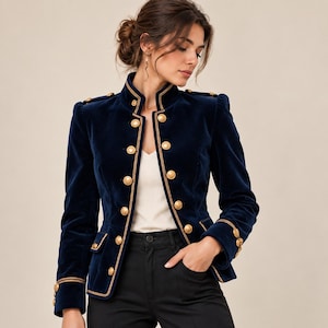 May include: A navy blue velvet military-style jacket featuring a high collar, structured shoulders, and gold-toned buttons arranged in a double-breasted pattern. The jacket is accented with gold piping along the edges, cuffs, and pockets.