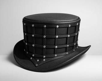 May include: Black top hat with a wide brim. The hat features a cage-like design around the crown, secured with silver-colored rivets. The hat is made of a leather-like material and is suitable for cosplay or costume events.