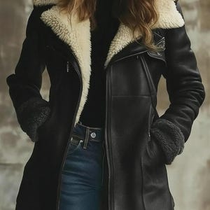 Peut inclure: Veste en cuir noire avec doublure et col en peau de mouton cr&egrave;me. La veste a une fermeture &eacute;clair, des poches et des poignets en peau de mouton. Le mod&egrave;le porte un jean bleu et un haut noir. V&ecirc;tement d'ext&eacute;rieur &eacute;l&eacute;gant.
