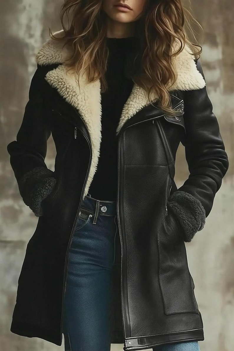 Peut inclure: Veste en cuir noire avec doublure et col en peau de mouton cr&egrave;me. La veste a une fermeture &eacute;clair, des poches et des poignets en peau de mouton. Le mod&egrave;le porte un jean bleu et un haut noir. V&ecirc;tement d'ext&eacute;rieur &eacute;l&eacute;gant.