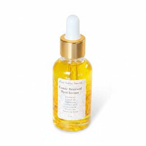 May include: A clear glass bottle of Lunar Renewal Spot Serum with a gold cap and white dropper. The bottle contains a yellow liquid and has a white label with the product name and ingredients: Jojoba oil, Castor oil, Calendula, Licorice root, Chamomile, Green tea, and Turmeric root. The bottle is 1 oz.