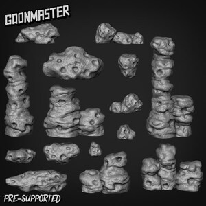 May include: A selection of grey, textured rock formations in various shapes and sizes. Some rocks feature holes and irregular surfaces. The image includes the text "GOONMASTER" and "PRE-SUPPORTED".