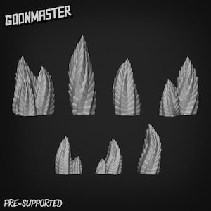 May include: A selection of grey, spiky, organic-looking forms, possibly for a miniature or model. The forms vary in size and shape, with a textured surface. The text "GOONMASTER" and "PRE-SUPPORTED" are visible.