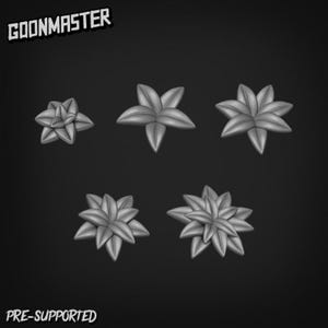 May include: Five grey, stylised flower-shaped objects against a dark background. The objects vary in size and have multiple pointed petals. The text "GOONMASTER" and "PRE-SUPPORTED" are in the image.