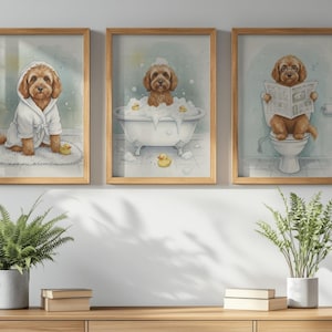 May include: Three framed watercolour prints depicting a brown dog in bathroom scenes. One shows the dog in a white robe, another in a bathtub, and the last on a toilet reading a newspaper. Each print is in a light wood frame.