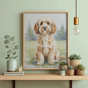 May include: A framed watercolour print of a light brown dog with floppy ears, sitting on green grass. The dog has a fluffy coat and is looking directly at the viewer. The artwork is displayed on a wooden shelf with potted plants.
