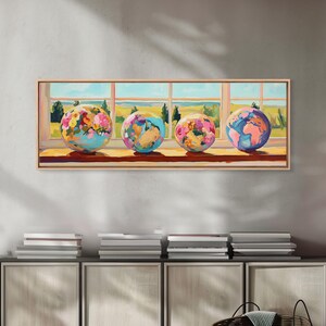 May include: A rectangular wall art print featuring four spherical globes resting on a windowsill. The globes display abstract floral patterns in shades of pink, yellow, blue, and orange. The background shows a landscape view through a window.