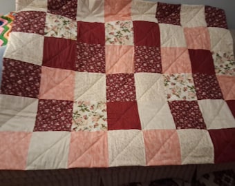 Large handmade patchwork quilt in large squares of burgundy, pink and beige prints. Made in a pet  and smoke free home.