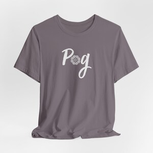 May include: A gray t-shirt with the word "Pog" in white script. The "o" in "Pog" is replaced with a decorative floral design. The shirt is made of a soft material and has short sleeves.