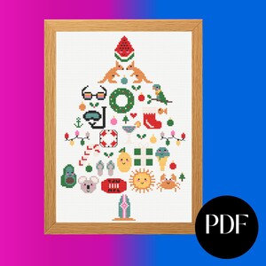 Könnte beinhalten: Kreuzstich-Kunstwerk in einem Holzrahmen, geformt wie ein Weihnachtsbaum, mit sommerlichen Symbolen. Enthält eine Wassermelone, Kängurus, Sonnenbrillen, einen Schnorchel, einen Kranz, einen Papagei und eine Krabbe. Der Hintergrund ist weiß.