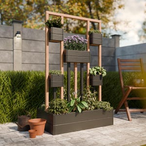 May include: An outdoor wooden planter with several dark grey rectangular plant boxes. The planter features a light brown wooden frame and is filled with various green plants and purple flowers. A small terracotta pot and watering can are in the foreground.