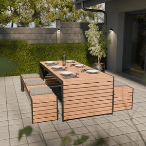 Op de afbeelding: Houten eethoek voor buiten met een rechthoekige tafel en twee banken. De tafel is gedekt met borden, glazen en bestek. De banken hebben grijze kussens. De set staat op een terras met een groene haag op de achtergrond.