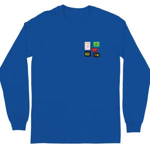 May include: Royal blue long-sleeve shirt with a small graphic design on the chest. The design includes the text "pasta dept." and other colorful graphics. The shirt is made of a soft material.