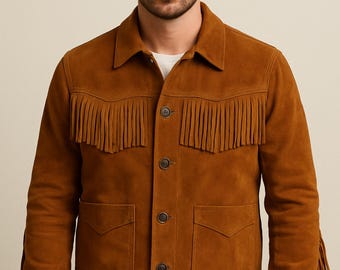 May include: A brown suede jacket with fringe detailing across the chest, shoulders, and sleeves. The jacket has a button-up front, two front pockets, and a collared neckline. The jacket is a medium brown color and appears to be a western-style design.