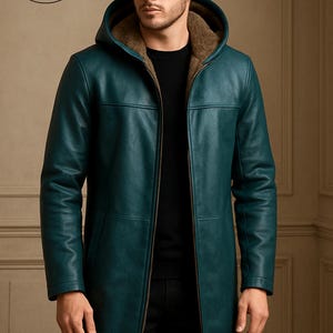 May include: Teal leather hooded coat with a zip closure. The coat has a brown fur-lined hood and a long, tailored fit. The coat is from Planio Leather, as indicated by the logo on the upper left.