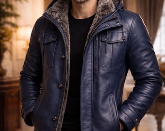 May include: A navy blue leather jacket with a fur-lined hood. The jacket has a button-up front, multiple pockets, and a zipper closure. The "PLANIO LEATHER" logo is visible in the upper left corner. The jacket is worn by a person.