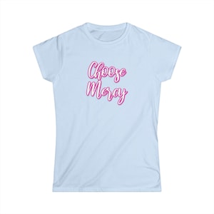 May include: Light blue t-shirt with the words "Choose Mercy" in pink script. The shirt has short sleeves and a crew neck. The text is in a cursive font.