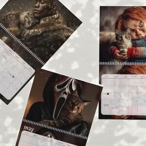 May include: Calendars featuring horror movie characters holding cats. One calendar shows a person holding a cat, another features Chucky with a cat, and a third shows the Ghostface mask with a cat. Each calendar has a spiral binding and a monthly layout.