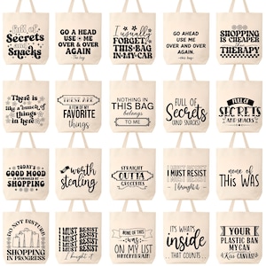 K&ouml;nnte beinhalten: Eine Auswahl an beigefarbenen Canvas-Tragetaschen mit verschiedenen schwarzen Textdesigns. Die Taschen zeigen humorvolle S&auml;tze wie "Secrets and Snacks", "Shopping is Cheaper Than Therapy" und "I Must Resist". Jede Tasche hat zwei Griffe.