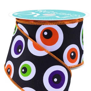 May include: A roll of black fabric ribbon featuring a repeating pattern of large, colorful eyeballs in shades of orange, purple, and green with white sclera. The edges of the ribbon are finished with a vibrant orange stitched border detail.