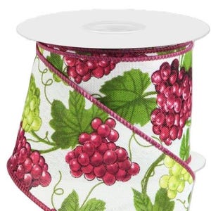 May include: A roll of decorative ribbon featuring a repeating pattern of red grapes, green leaves, and vines on a white background. The ribbon has a burgundy edge and is ideal for crafts and gift wrapping.