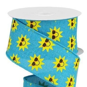 May include: A spool of turquoise ribbon with a repeating pattern of yellow suns wearing sunglasses. The ribbon has a textured appearance and is suitable for crafts and decorations. The spool is white.