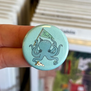 Puede incluir: Un botón redondo azul claro con un pulpo de dibujos animados que lleva un gorro de fiesta y sostiene una bandera con la palabra "Party". El pulpo también sostiene una porción de pizza. Diseño divertido y caprichoso.