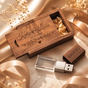 Pode incluir: Uma pen drive e uma caixa de madeira com os nomes "Katie & Louis" e a data "12-2-2023" gravados. A caixa está aberta, revelando pétalas secas. A pen drive tem um corpo retangular transparente.