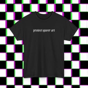 May include: A black short-sleeved t-shirt featuring the white text "protect queer art" printed in a gothic-style font across the center of the chest. The garment has a standard crew neckline and a straight hemline, presented in a simple design.