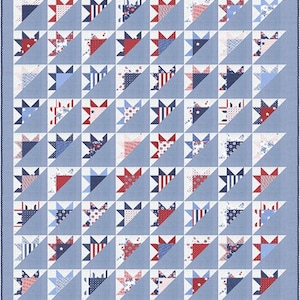 May include: A patchwork quilt with a repeating pattern of red, white, and blue star and triangle shapes. The quilt has a light blue background and a dark blue border. The stars and triangles are made of various patterned fabrics.