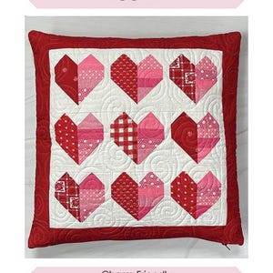 May include: A red and white heart-shaped pillow with a quilted design. The pillow is 18 inches by 18 inches and is charm friendly. The pillow is labeled "Heartstrings Pillow" and is by Chrissy Lux of Sew Lux Fabric.
